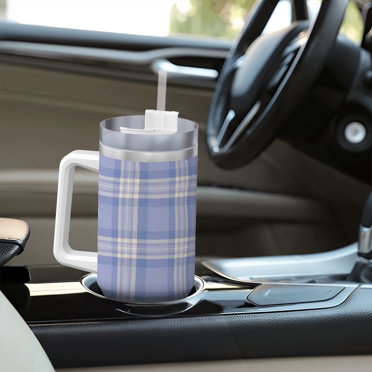 Plaid-patterned mug with a straw on a car's cup holder