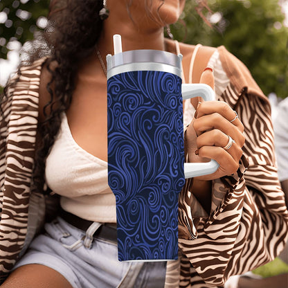 Person holding a blue patterned tumbler with a blurred background