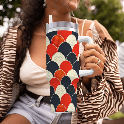 Person holding a colorful tumbler with geometric pattern outdoors