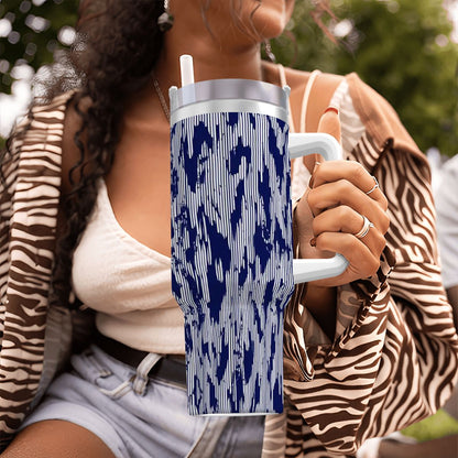 Person holding a blue and white patterned tumbler outdoors