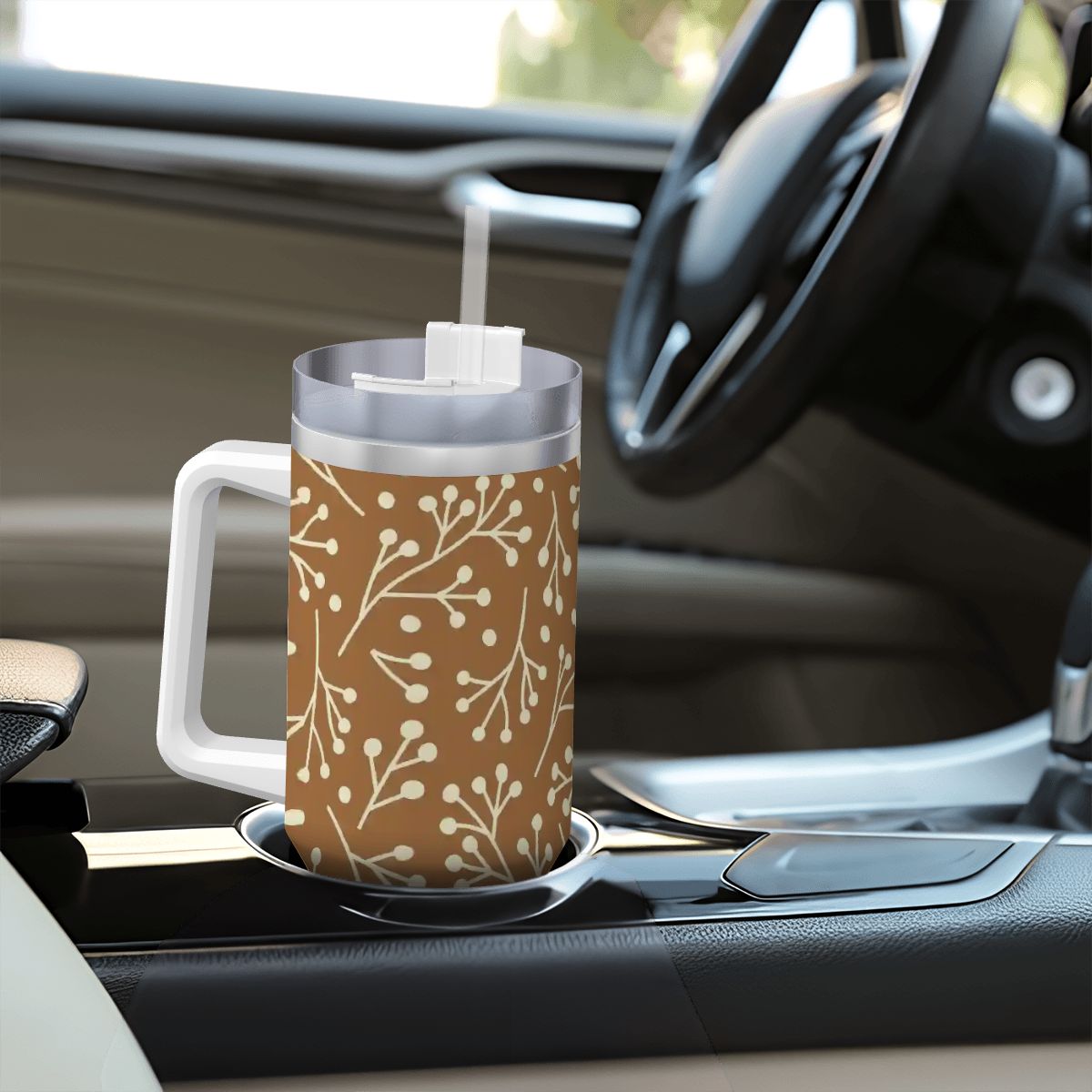 Travel mug with a brown floral pattern on a car dashboard
