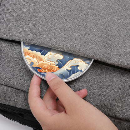 Hand placing a decorative wireless charger with wave design on a gray fabric surface