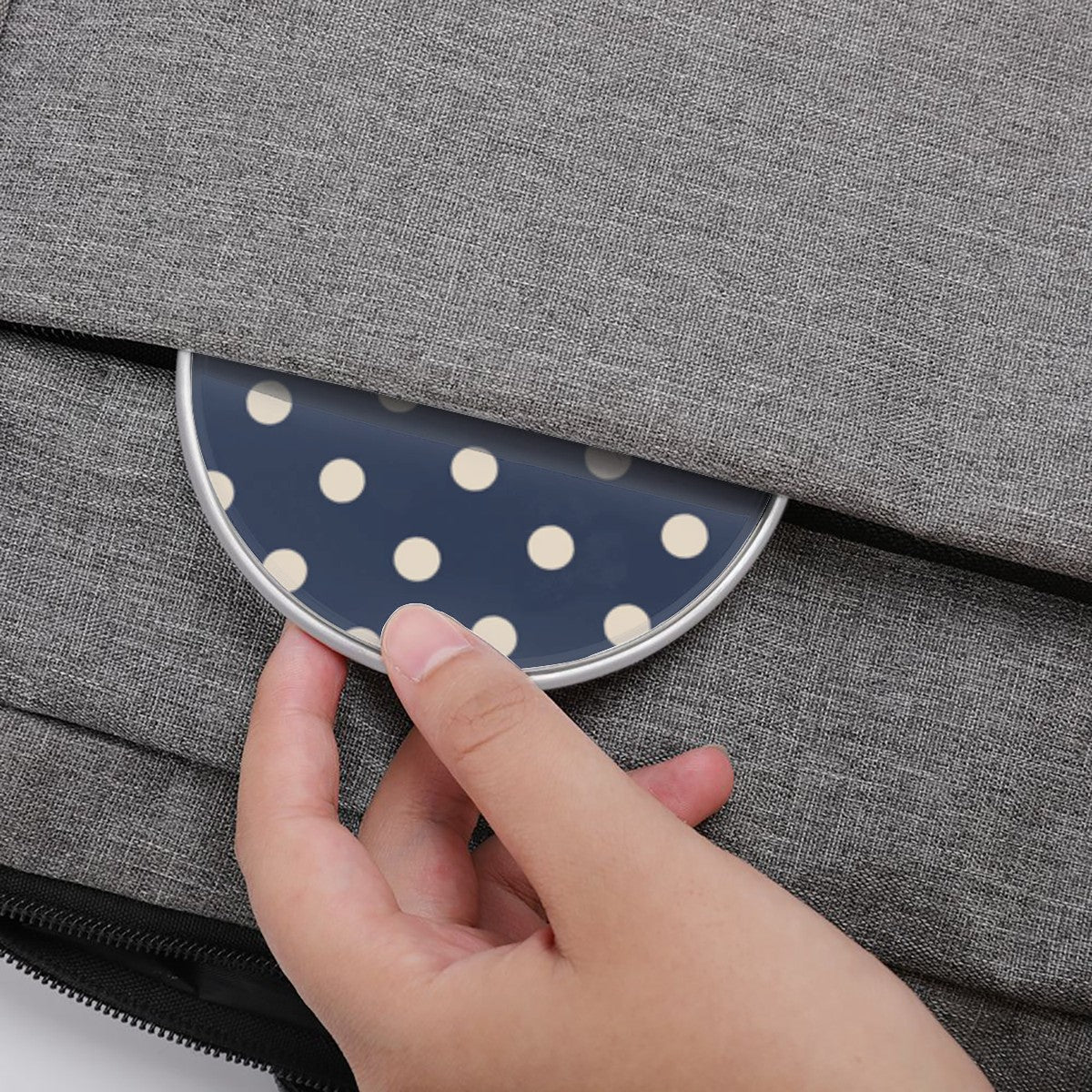 Hand placing a polka dot coaster on a gray textured surface