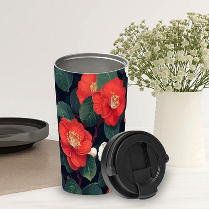 Tumbler with red floral design on a white surface with a vase of flowers in the background