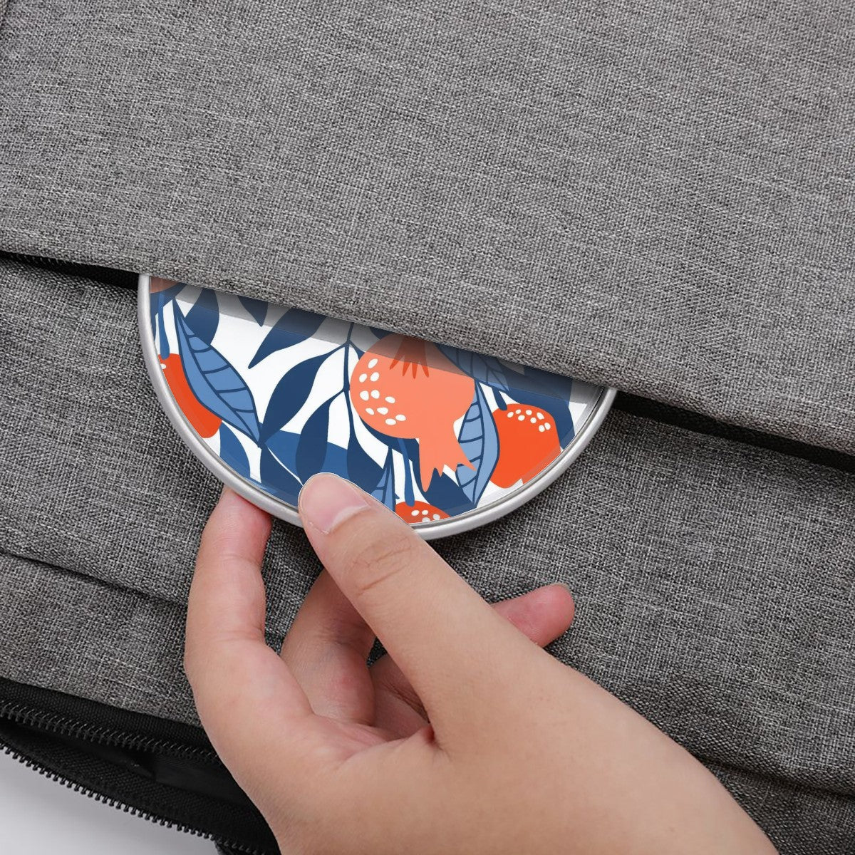 Hand pressing a floral-patterned button on a gray textured surface