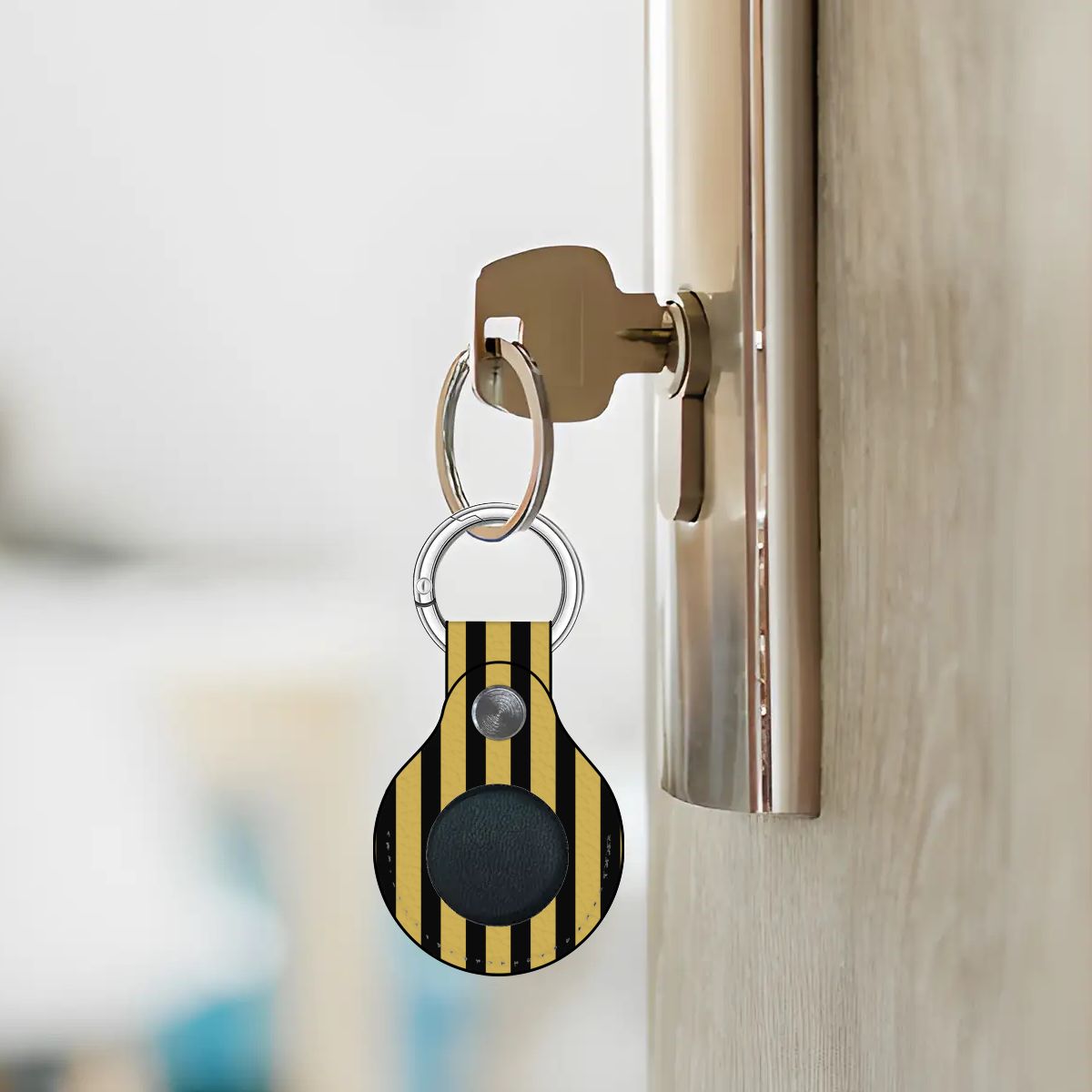 Keychain with a black and yellow striped design attached to a door handle.