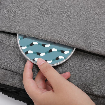 Hand opening a gray textured bag with a circular blue and white patterned pocket.
