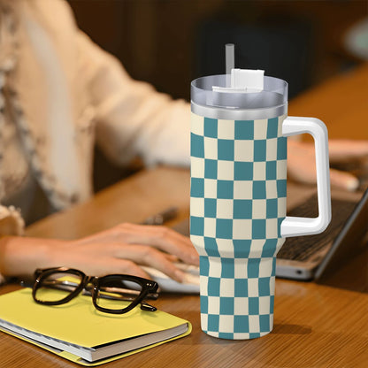 Checkered mug with handle on a desk next to glasses and a notebook