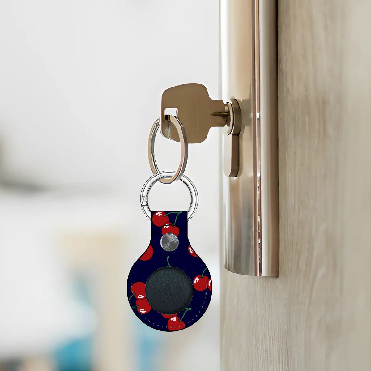 Keychain with a cherry pattern attached to a door handle.