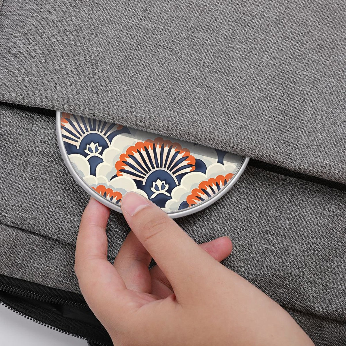 Hand placing a decorative coaster on a gray textured surface