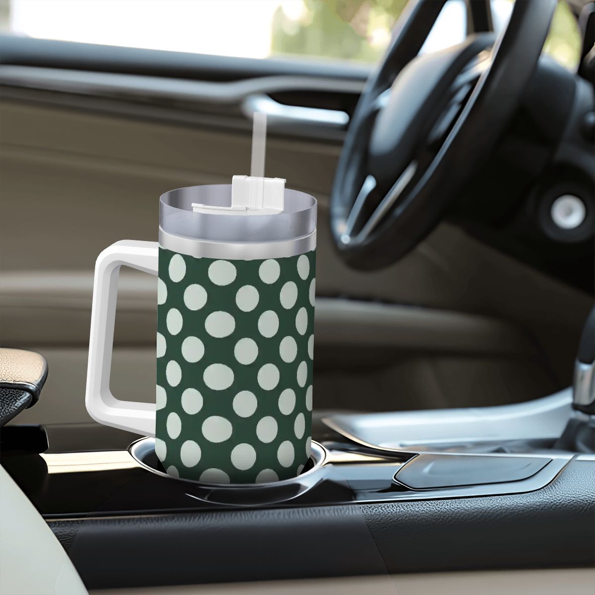 Green polka dot mug with a straw on a car dashboard