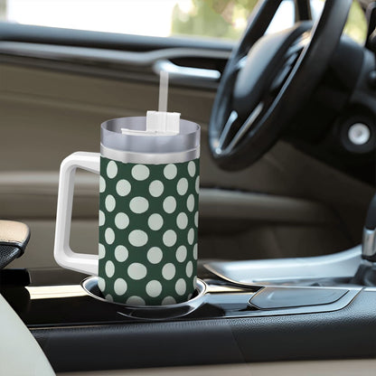 Green polka dot mug with a straw on a car dashboard