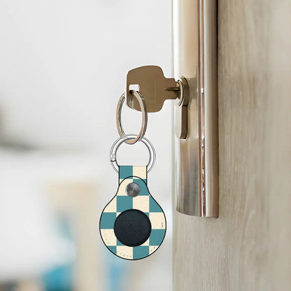 Keychain with a black round device attached to a door handle.