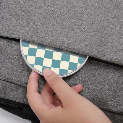Hand placing a round checkered object on a gray textured surface
