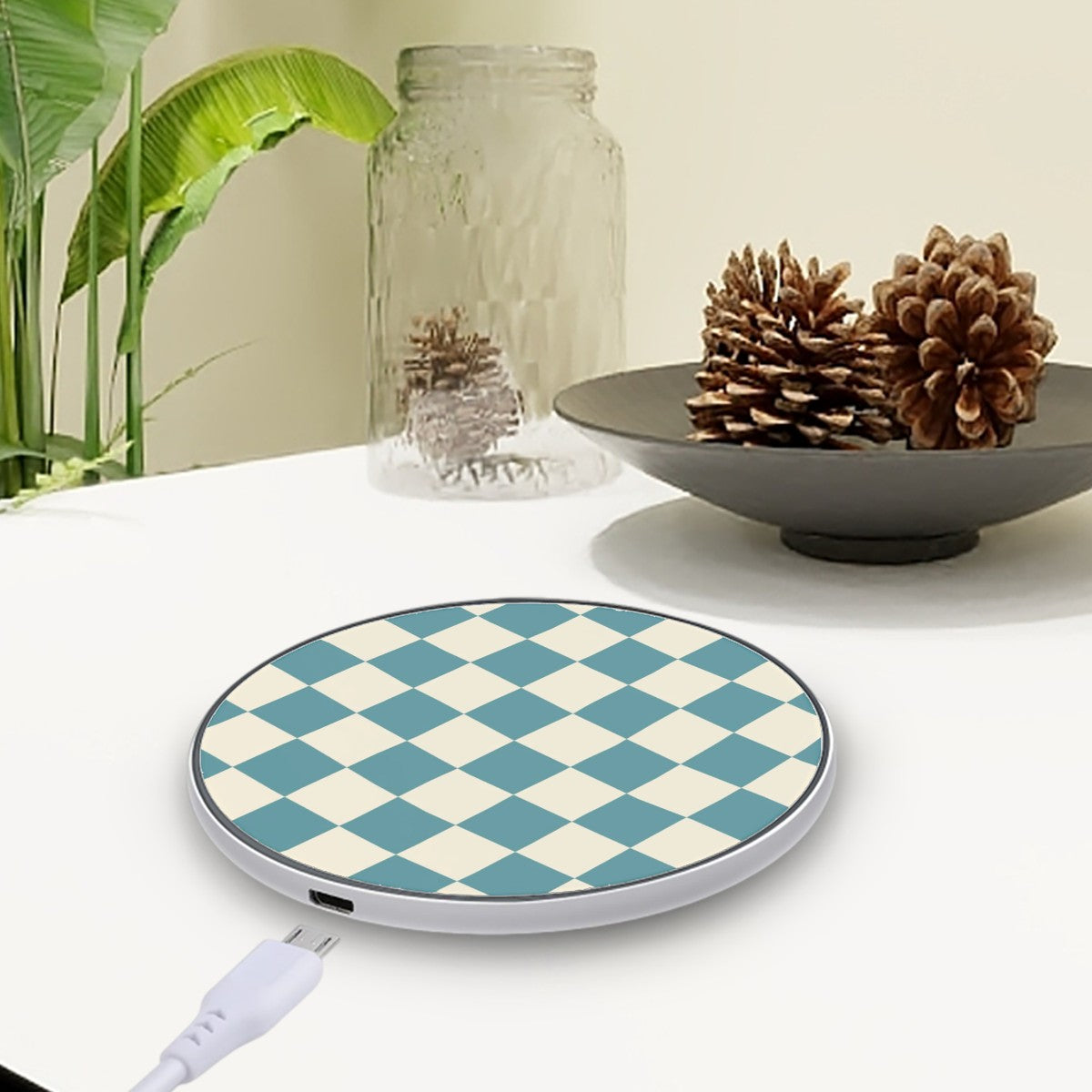 Wireless charging pad with blue and white checkered design on a table with decorative items.