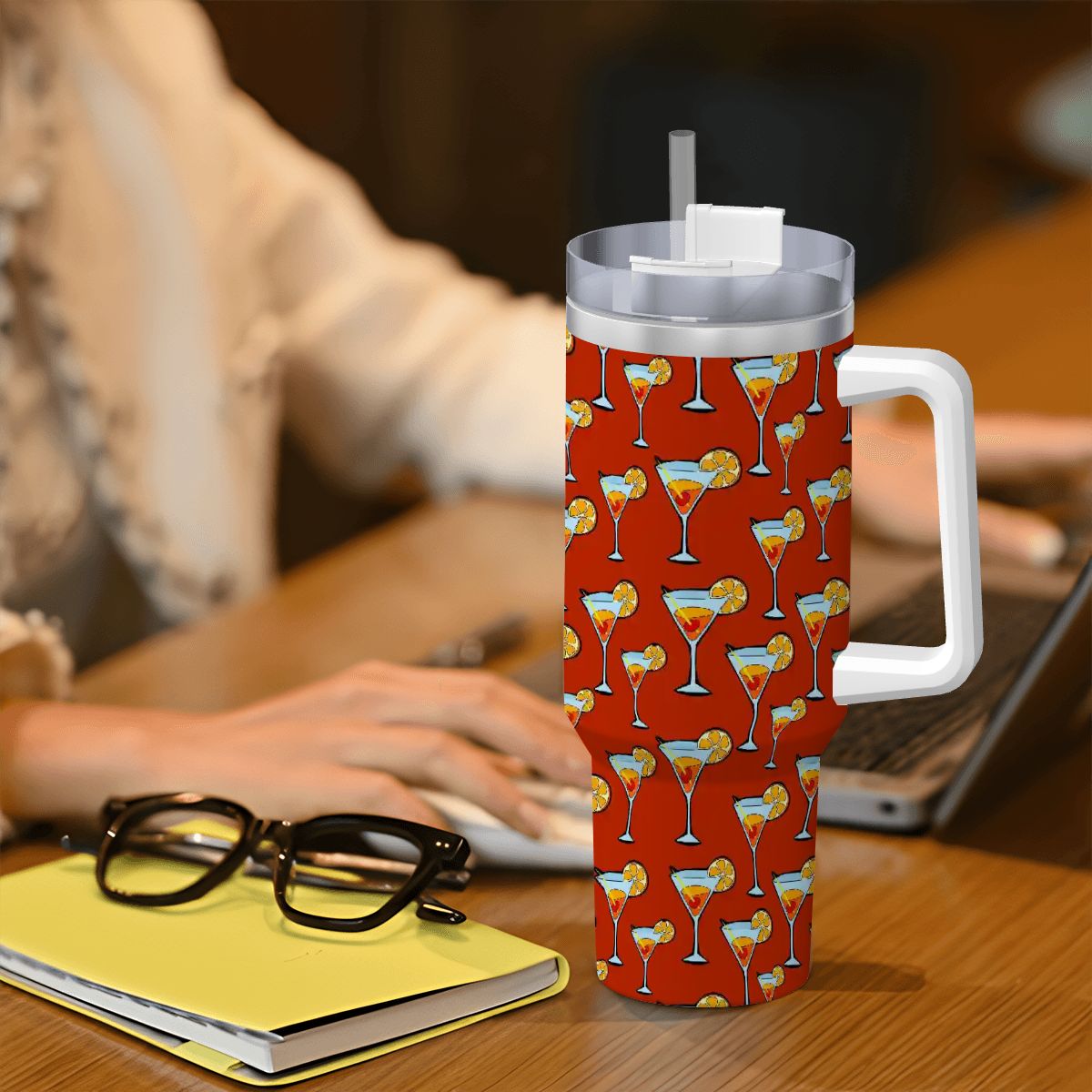 Red mug with cocktail pattern on a desk with glasses and notebook