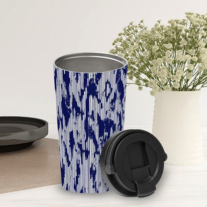 Blue and white patterned tumbler with black lid on a light surface with flowers in the background