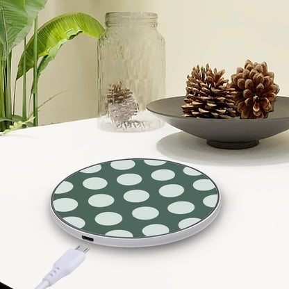 Green and white polka dot wireless charging pad on a table with decorative items.