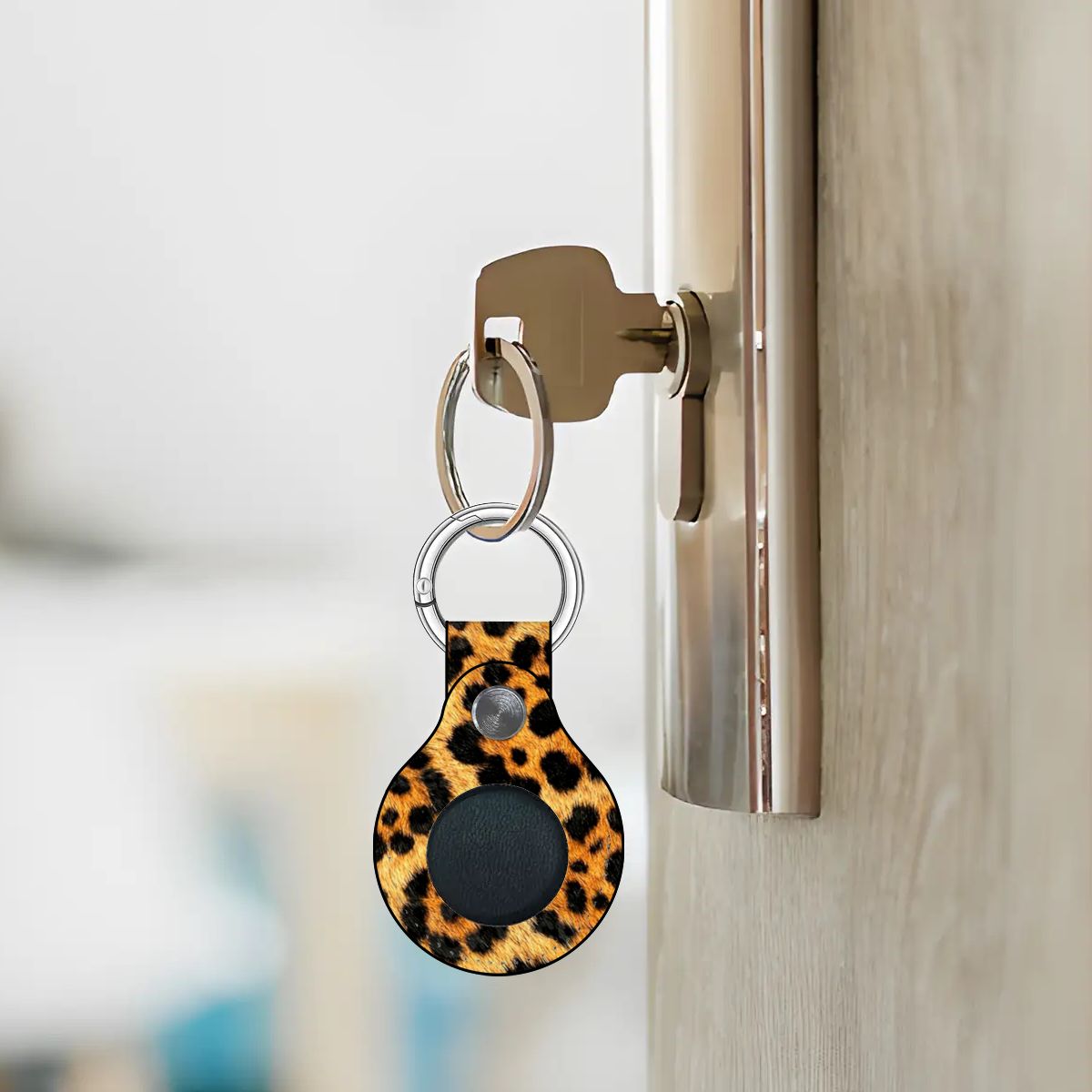 Leopard print keychain attached to a door handle with a blurred background